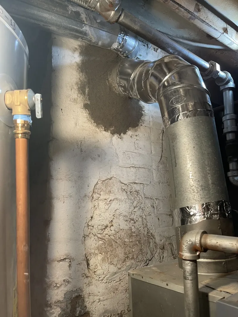Boiler flue pipe connected to a masonry chimney in a basement