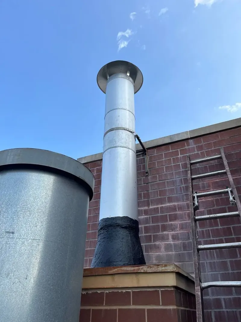 Metal chimney extension on top of a brick chimney