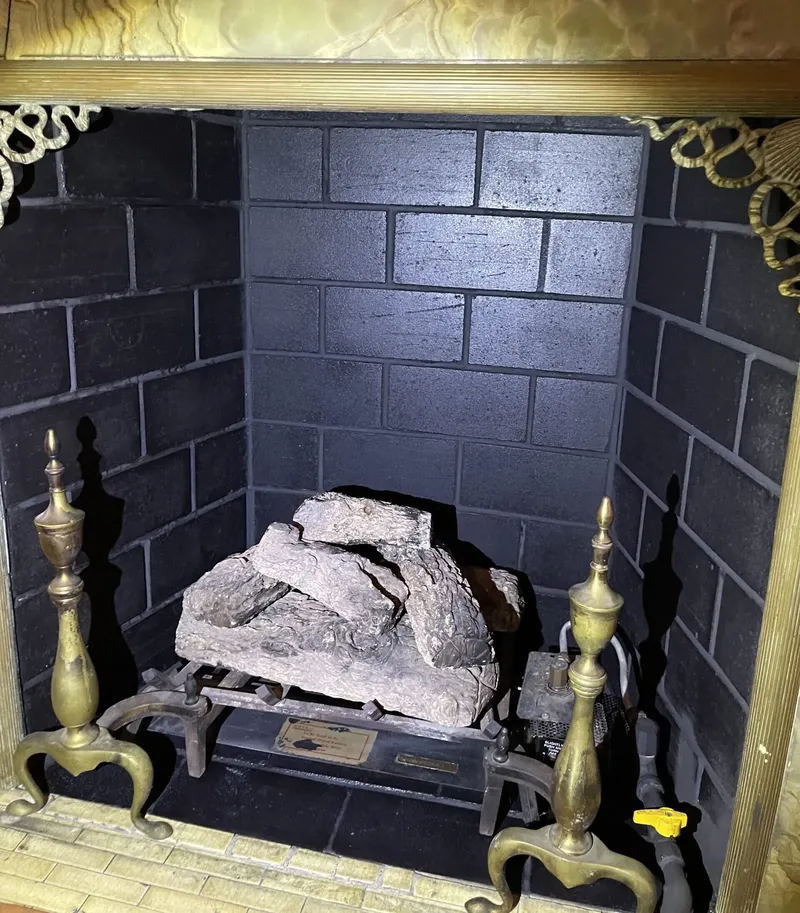 Firebox with andirons and black painted brick