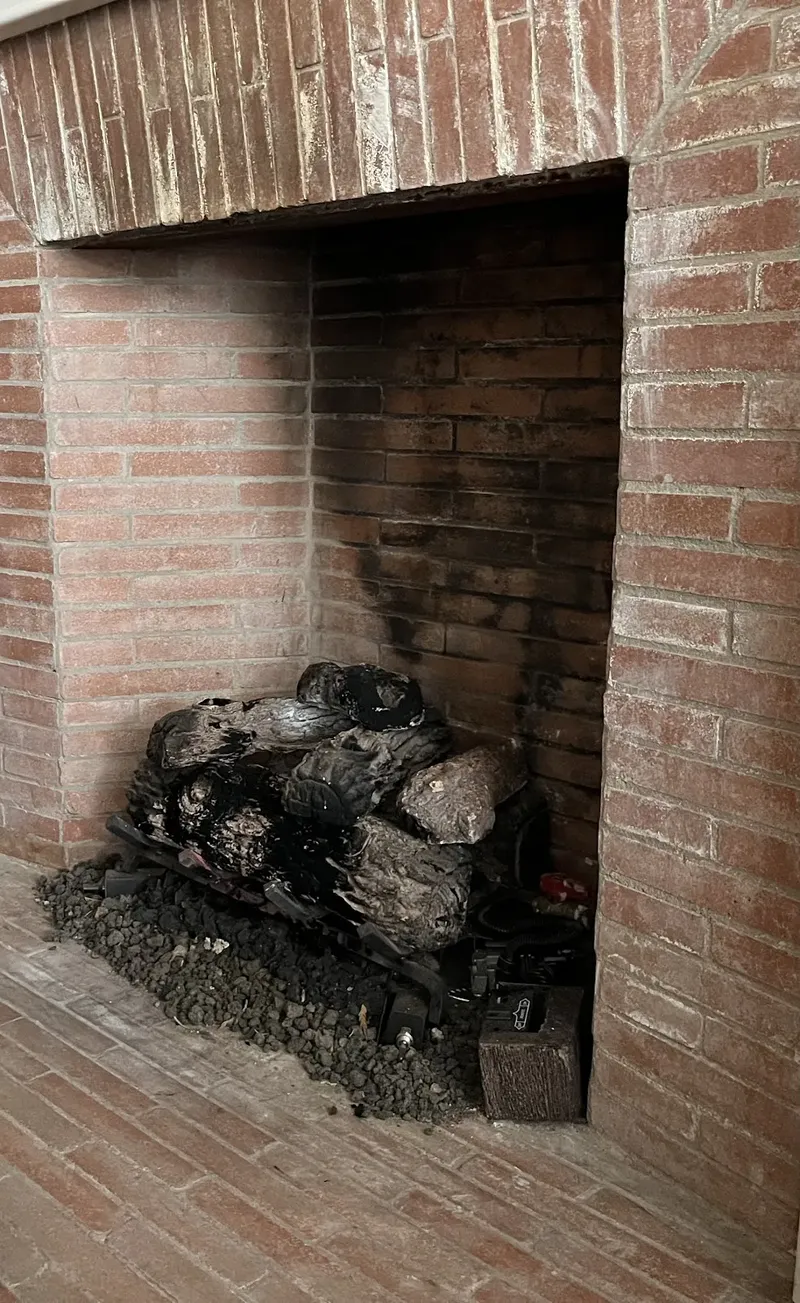 Brick fireplace with a stack of logs