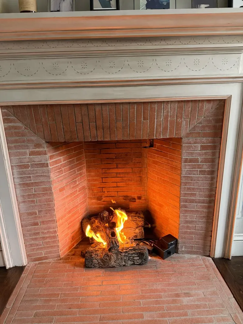 Fire burning in a brick fireplace with a white mantel