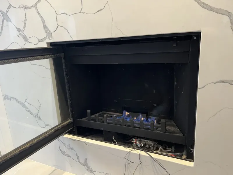 Gas fireplace insert with the glass front open