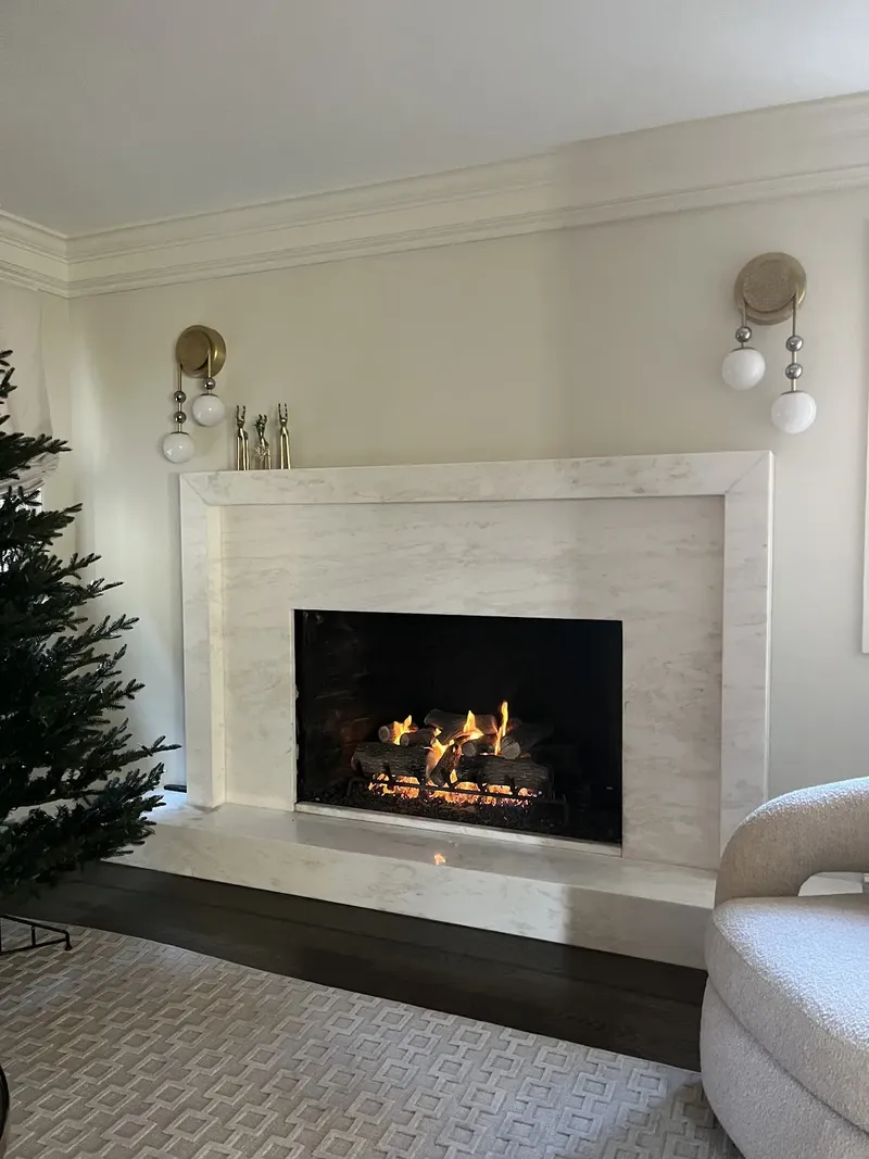 Gas fireplace with a white stone surround in a living room