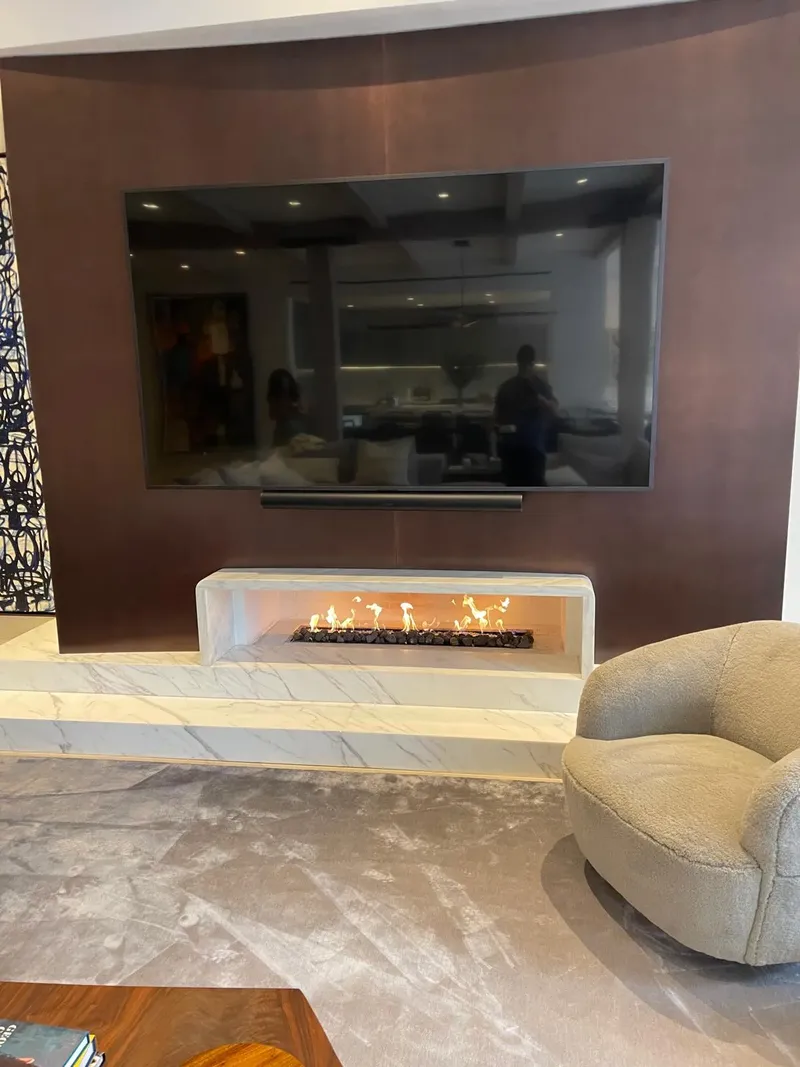 Modern linear gas fireplace below a wall-mounted TV