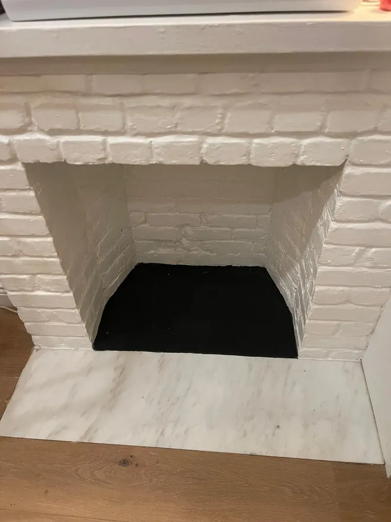 Painted white brick fireplace after a repair