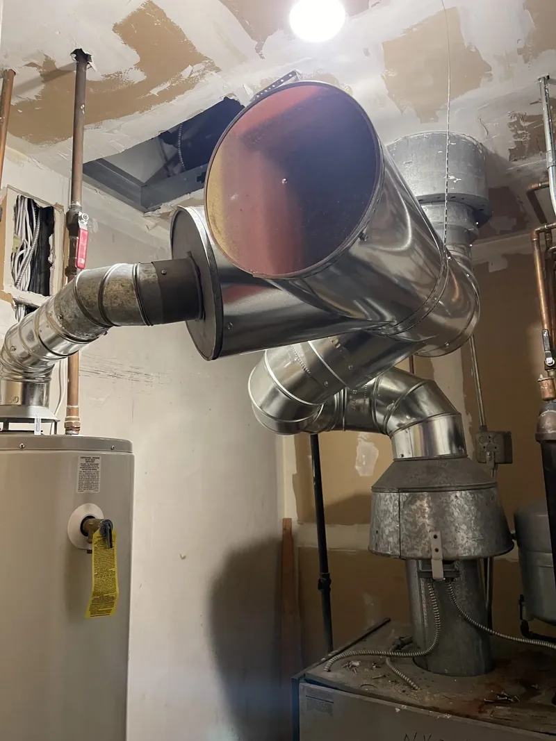 Stainless steel vent pipes connecting a water heater to the chimney